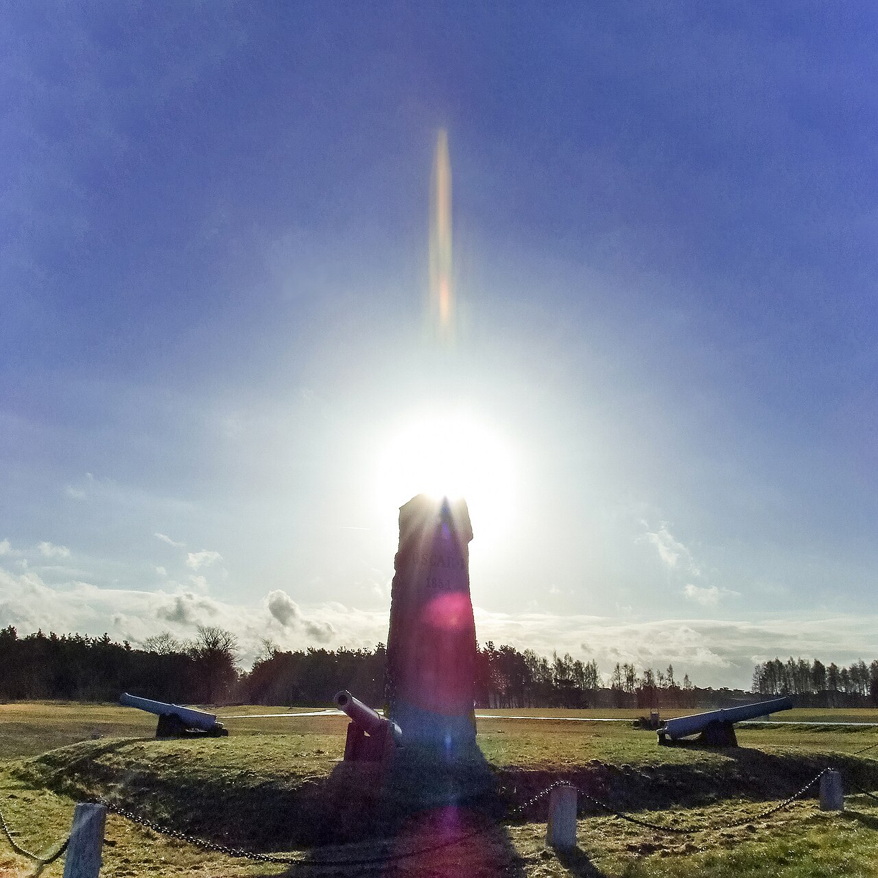 Lens flare from the sun behind a monument
